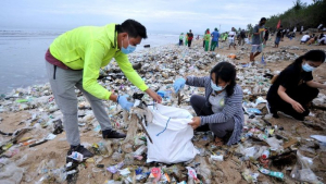 Relawan membersihkan sampah yang berserakan saat mengikuti aksi bersih sampah di Pantai Kuta, Badung, Bali, Rabu (6/1/2021). 